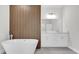 Modern bathroom features a freestanding tub, wood accent wall, double vanity, and neutral color palette at 601 Marion Oaks Blvd, Ocala, FL 34473