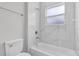 Bright bathroom with white marble tile, bathtub, and modern fixtures at 601 Marion Oaks Blvd, Ocala, FL 34473