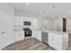 Bright kitchen features stainless steel appliances, white cabinetry, and modern pendant lighting at 601 Marion Oaks Blvd, Ocala, FL 34473