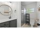 Modern bathroom featuring a sleek vanity, round mirror, and glass shower at 62 Magnolia Dr, Debary, FL 32713