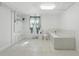 Bright and modern bathroom featuring a tub and shower, white tile, and stylish fixtures at 62 Magnolia Dr, Debary, FL 32713