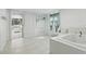 Bright and modern bathroom featuring a tub and shower, white tile, and stylish fixtures at 62 Magnolia Dr, Debary, FL 32713