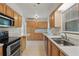 Well-lit kitchen with wood cabinets, stainless steel appliances, and tile flooring at 62 Magnolia Dr, Debary, FL 32713