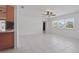 Bright living room with tile flooring, ceiling fan, and large windows, adjacent to the kitchen at 62 Magnolia Dr, Debary, FL 32713