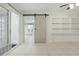 Open living area with tile floors, a sliding glass door, and a unique barn door at 62 Magnolia Dr, Debary, FL 32713