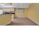 Dining area featuring a large world map, kitchen pass-through, and neutral carpet flooring at 725 Crest Pines Dr # 422, Orlando, FL 32828
