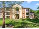 View of the two-story apartment complex with patios, lush landscaping, and picturesque water feature in front at 725 Crest Pines Dr # 422, Orlando, FL 32828