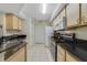 Bright kitchen featuring black countertops, stainless steel appliances, and white tile flooring at 725 Crest Pines Dr # 422, Orlando, FL 32828