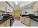 Well-lit kitchen with black countertops, light wood cabinets, and stainless steel appliances at 725 Crest Pines Dr # 422, Orlando, FL 32828