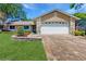 Charming single-Gathering home featuring a brick driveway and a well-manicured front yard at 7845 Clubhouse Estates Dr, Orlando, FL 32819