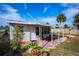 Charming backyard features a brick patio, tropical plants, and sunny skies, perfect for outdoor relaxation at 8 Palm Dr, Ormond Beach, FL 32176