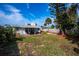 Wide backyard view with a brick patio with chairs in front of the home at 8 Palm Dr, Ormond Beach, FL 32176