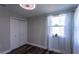 Bedroom with wood-look floors, closet with bifold doors, and window with curtains at 8 Palm Dr, Ormond Beach, FL 32176