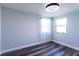 Bedroom with wood-look floors, neutral paint, and large windows with sheer curtains at 8 Palm Dr, Ormond Beach, FL 32176