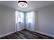 Bedroom with wood-look floors, neutral walls, and windows with sheer white curtains at 8 Palm Dr, Ormond Beach, FL 32176