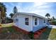 Angle shot showing the fresh paint, new windows, attractive lawn, and landscaping at 8 Palm Dr, Ormond Beach, FL 32176