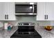 Close-up view of modern kitchen with stainless steel microwave and electric range oven at 8 Palm Dr, Ormond Beach, FL 32176