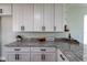 Bright kitchen with modern granite countertops, white cabinets, and stylish dark hardware, a chef's dream at 8 Palm Dr, Ormond Beach, FL 32176