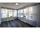 Sun room with large windows and sheer, decorative curtains and wood laminate flooring at 8 Palm Dr, Ormond Beach, FL 32176