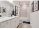 Bright bathroom featuring a white vanity with quartz countertop, and a shower-over-tub combination at 9132 Sw 57Th Ter, Ocala, FL 34476