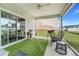 Relaxing screened patio featuring a grill, seating and artificial turf, perfect for outdoor enjoyment at 9132 Sw 57Th Ter, Ocala, FL 34476