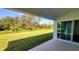 Covered patio with sliding glass doors overlooking a large backyard and wooded area at 1032 Morfontaine St, Daytona Beach, FL 32124