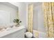 Clean bathroom with a vanity, toilet, and a shower/tub combination with yellow patterned shower curtains at 1035 Morfontaine St, Daytona Beach, FL 32124