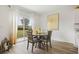 Dining room with round wooden table, four chairs, white sheer curtains and a sliding door to the yard at 1039 Morfontaine St, Daytona Beach, FL 32124