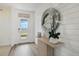 Bright entryway with white shiplap wall, decorative mirror, and a view of the outdoors through the front door at 1039 Morfontaine St, Daytona Beach, FL 32124