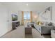 Bright living room boasts a gray sofa, modern furniture and large windows with yellow curtains at 1039 Morfontaine St, Daytona Beach, FL 32124