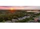 Panoramic aerial view of a neighborhood at sunset with lush trees, waterways, and glimpses of elegant homes at 10849 Emerald Chase Dr, Orlando, FL 32836