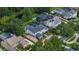 Aerial view of grand white two-story home with a private pool, tennis court, and meticulously landscaped grounds at 10849 Emerald Chase Dr, Orlando, FL 32836
