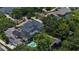 Sprawling estate aerial with luxurious pool, tennis court, boat dock, set amid lush landscaping, and stately homes at 10849 Emerald Chase Dr, Orlando, FL 32836