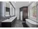 Luxurious bathroom featuring sleek vanities, soaking tub, and marble accents at 10849 Emerald Chase Dr, Orlando, FL 32836