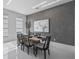 Modern dining room with stylish table, chairs, contemporary artwork, and sophisticated gray accent wall at 10849 Emerald Chase Dr, Orlando, FL 32836