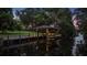 The illuminated boat dock and lift at dusk on the water at 10849 Emerald Chase Dr, Orlando, FL 32836
