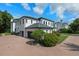 Rear view of a stately home with attached garage, paved driveway, and manicured landscaping at 10849 Emerald Chase Dr, Orlando, FL 32836