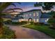 Elegant white home with arched entrance, meticulously landscaped lawn and brick driveway creates a welcoming approach at 10849 Emerald Chase Dr, Orlando, FL 32836