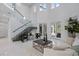 Bright and airy living room with soaring ceilings, glass staircase, and sleek, modern furniture at 10849 Emerald Chase Dr, Orlando, FL 32836