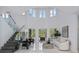 Bright and airy living room with soaring ceilings, glass staircase, and sleek, modern furniture at 10849 Emerald Chase Dr, Orlando, FL 32836