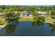 Aerial shot of a lakefront property with a private dock and solar panels surrounded by greenery at 1103 Lindley Cove Cir, Deland, FL 32724