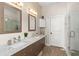Bathroom featuring double sinks with marble counters, framed mirrors and a glass enclosed shower at 1103 Lindley Cove Cir, Deland, FL 32724