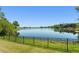 Scenic view of a lake surrounded by lush greenery, framed by a black metal fence at 1103 Lindley Cove Cir, Deland, FL 32724