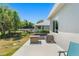 A stone patio with a modern outdoor table and seating area plus a view of the manicured lawn at 1103 Lindley Cove Cir, Deland, FL 32724