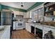 Outdated kitchen with white cabinets and stainless steel refrigerator at 1136 Lakewood Park Dr, Daytona Beach, FL 32117