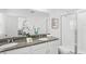 Elegant bathroom featuring a double vanity with granite countertop and a glass-enclosed shower at 1168 Lakeshore Breeze Pl, Kissimmee, FL 34747