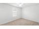 Bright bedroom featuring neutral carpeting, white walls, a ceiling fan, and a window at 1168 Lakeshore Breeze Pl, Kissimmee, FL 34747