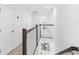 Bright hallway with white walls and carpet, a wooden railing, and views of downstairs at 1168 Lakeshore Breeze Pl, Kissimmee, FL 34747