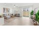 Bright living room featuring neutral tones, tile flooring, and sliding glass doors leading to the backyard at 1168 Lakeshore Breeze Pl, Kissimmee, FL 34747