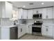 Modern kitchen featuring stainless steel appliances, white cabinets, quartz countertops, and recessed lighting at 1313 Pine Ridge Dr, Daytona Beach, FL 32117
